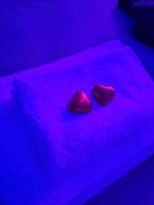 two red hearts are sitting on a purple bed at Tecaia Secret Luxury Suite in Formia +13 photos