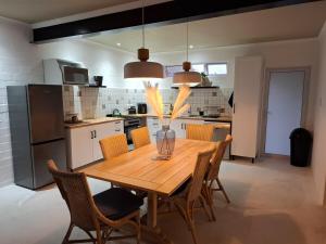 a kitchen with a wooden dining table and chairs at Embrace This Planet Self-Catering Accommodation in Fisherhaven