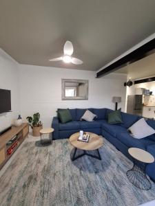 a living room with a blue couch and a table at Embrace This Planet Self-Catering Accommodation in Fisherhaven
