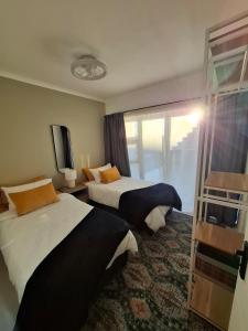 a hotel room with two beds and a television at Embrace This Planet Self-Catering Accommodation in Fisherhaven