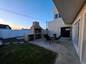 a patio with a table and chairs in a backyard at Embrace This Planet Self-Catering Accommodation in Fisherhaven
