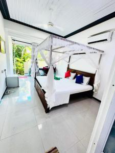 una camera da letto con un letto a baldacchino di Sajana Ocean Hill a Mirissa
