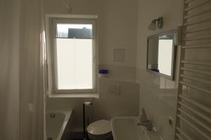 een badkamer met een wastafel en een toilet en een raam bij Steffis - Hof in Kurort Gohrisch +18 foto's