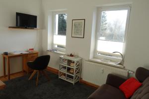 een woonkamer met een bank en twee ramen bij Steffis - Hof in Kurort Gohrisch