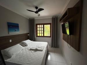 een slaapkamer met een bed en een televisie. bij AP Beira da Lagoa da Conceição in Florianópolis