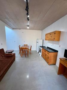 een keuken en eetkamer met een tafel en een bank bij Casa quadra-mar com piscina in Rio Grande
