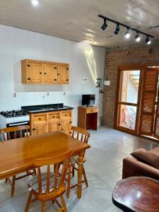 een woonkamer met een houten tafel en een keuken bij Casa quadra-mar com piscina in Rio Grande