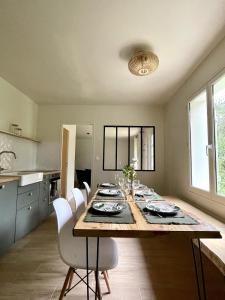 a kitchen and dining room with a table and chairs at L'Échappée Boisée - côté Vallée in Chambon-sur-Cisse