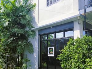 a building with a palm tree in front of it at Green Turtle Backpackers Guesthouse, Puerto Princesa in Puerto Princesa City