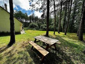 a wooden picnic table sitting in the grass near trees at L'Échappée Boisée - côté Vallée in Chambon-sur-Cisse