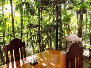 a wooden table with two chairs and a tea kettle on top at Green Turtle Backpackers Guesthouse, Puerto Princesa in Puerto Princesa City