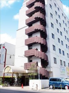 een hoog gebouw met een sculptuur aan de zijkant bij Tsuyama Central Hotel Townhouse in Tuyama