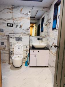 une salle de bains avec toilettes et lavabo dans l'établissement Hotel Seven Pahalgam, à Pahalgām