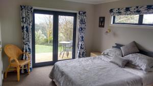 a bedroom with a bed and a sliding glass door at Omaka Heights Countrystay in Renwick
