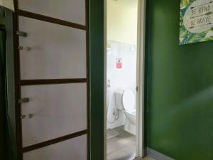 a door leading to a bathroom with a toilet at Green Turtle Backpackers Guesthouse, Puerto Princesa in Puerto Princesa City +28 photos