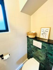 a bathroom with a toilet and a basket on a shelf at Casa Loua in Blankenberge