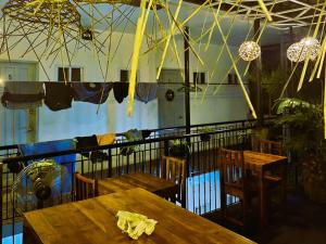 een restaurant met houten tafels, stoelen en verlichting bij Green Turtle Backpackers Guesthouse, Puerto Princesa in Puerto Princesa City