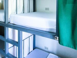 een stapelbed in een kamer naast een raam bij Green Turtle Backpackers Guesthouse, Puerto Princesa in Puerto Princesa City +31 foto's