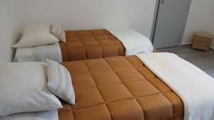 two beds with brown and white sheets and pillows at VILLARGONDRAN vélos en Maurienne garage motos in Villargondran