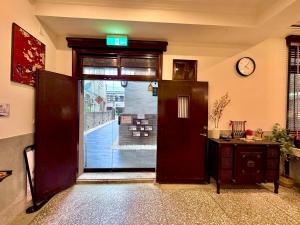 a door in a room with a clock on the wall at 櫻花樹夏民宿 in Zhunan