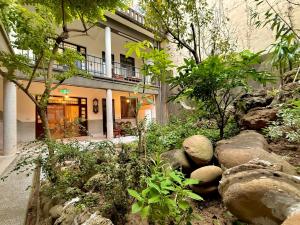 a garden with rocks in front of a building at 櫻花樹夏民宿 in Zhunan
