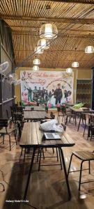une chambre avec des tables, des chaises et un grand écran dans l'établissement Trang An Green Bungalow & Restaurant, à Ninh Binh