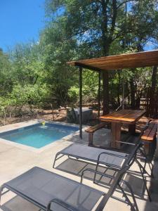 a picnic table and chairs next to a swimming pool at Mukaya Haven in Marloth Park