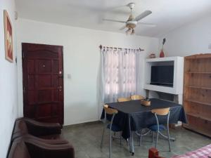 een eetkamer met een tafel met stoelen en een tv bij Casa Doña Victoria in Villa Carlos Paz