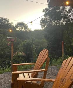 2 sedie in legno sedute l'una accanto all'altra su un patio di Cabana Pouso Sereno a Domingos Martins