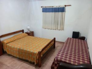 een slaapkamer met twee bedden en een raam bij Casa Doña Victoria in Villa Carlos Paz