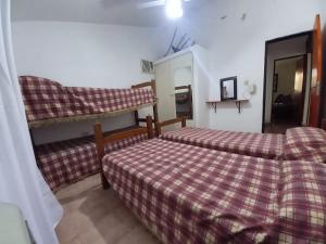 een slaapkamer met twee bedden en een spiegel bij Casa Doña Victoria in Villa Carlos Paz