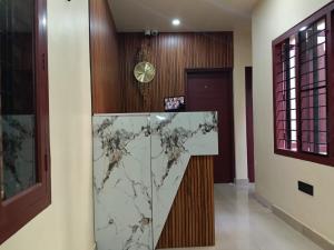 een lobby met een marmeren bar en een klok bij SJ Homes in Karukachal