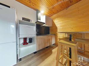 una cucina con pareti in legno e pavimenti in legno di Le Chitelet vue sur pistes a Xonrupt-Longemer 1 altra foto