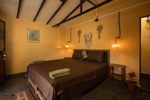 een slaapkamer met een bed met twee handdoeken erop bij Deepiksha Beach Resort Talpona in Magdāl