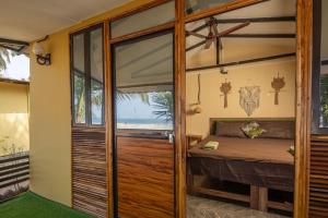 een slaapkamer met een bed en een grote glazen deur bij Deepiksha Beach Resort Talpona in Magdāl