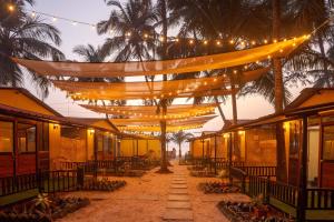 een lichtslinger die boven een straat met palmbomen hangt bij Deepiksha Beach Resort Talpona in Magdāl +40 foto's