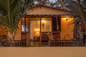 een huis met een kamer met een bank en stoelen bij Deepiksha Beach Resort Talpona in Magdāl