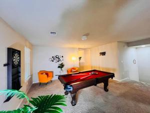 una camera con tavolo da biliardo e sedia arancione di Pool Table, Foosball, King bed, Crib,Parking&Yard a Kyle