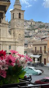 ein Gebäude mit einem Glockenturm mit einem Blumenstrauß in der Unterkunft Agira Royal Central Rooms in Agira
