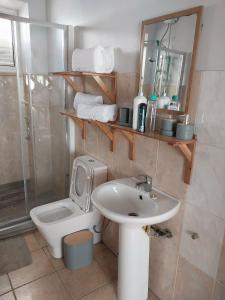 a bathroom with a toilet and a sink and a shower at Sol, Terra e Mar- No coração do Plateau in Praia