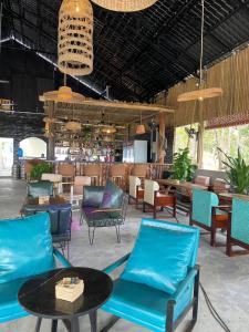 een lobby met blauwe stoelen en een tafel en een bar bij The Up Koh Rong in Kaôh Rŭng (3)