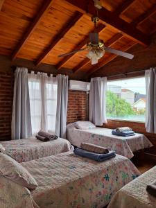 3 bedden in een kamer met een plafondventilator bij Estación Sur Mdp in Mar del Plata