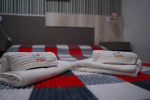 two stacks of towels sitting on top of a bed at Cabañas de Itacú in Chajarí