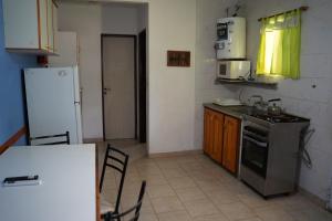 a kitchen with a refrigerator and a table and chairs at Cabañas de Itacú in Chajarí