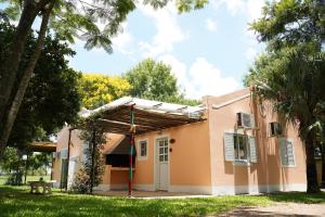 a house with a pergola on the side of it at Cabañas de Itacú in Chajarí