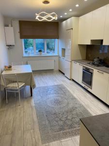 a kitchen with white cabinets and a table with a rug at Апартаменты in Izmail
