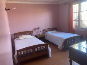 ein Schlafzimmer mit zwei Betten und einem Fenster in der Unterkunft Habitaciones en Casa de la Playa! in Quintero