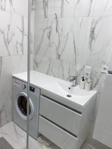 a bathroom with a washing machine and a sink at Апартаменты in Izmail