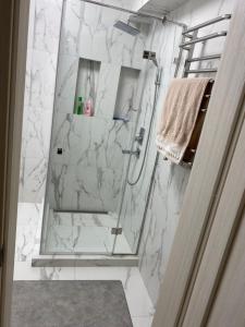 a bathroom with a shower with white marble at Апартаменты in Izmail