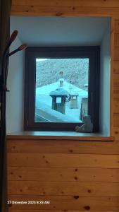 een televisiescherm met uitzicht op een tafel en sneeuw bij La cò viéyi - La casa vecchia in Ala di Stura +17 foto's